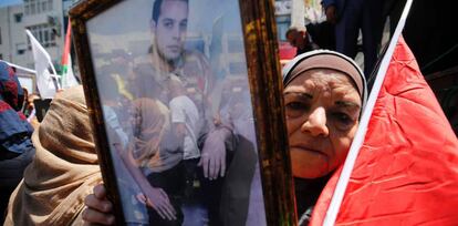 Una mujer muestra el retrato de un palestino preso en una c&aacute;rcel israel&iacute;, durante una protesta celebrada en Ramala este lunes.