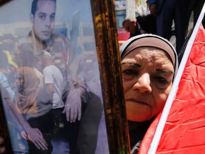 Una mujer muestra el retrato de un palestino preso en una c&aacute;rcel israel&iacute;, durante una protesta celebrada en Ramala este lunes.