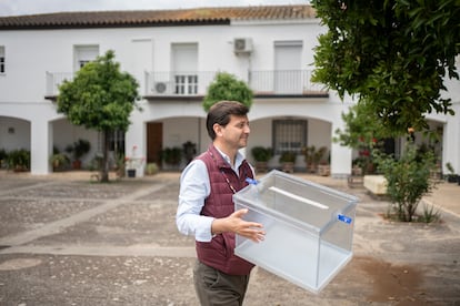 Un empleado municipal de Majarromaque lleva una urna electoral.