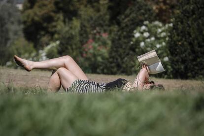 Una mujer lee un libro en el parque de la Ciutadella de Barcelona.