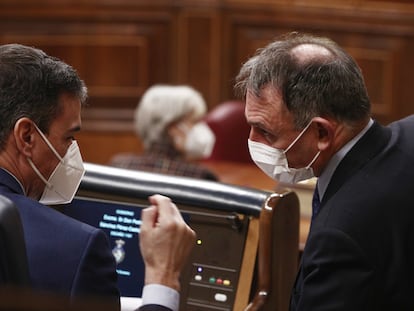 A la izquierda, el presidente del Gobierno, Pedro Sánchez, junto al diputado de Unidas Podemos, Enrique Santiago, el pasado 24 de febrero de 2021 en el Congreso de los Diputados.