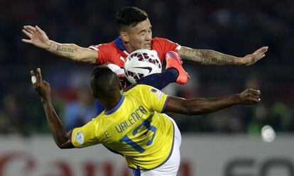 Valencia y Aranguiz luchan por un bal&oacute;n.