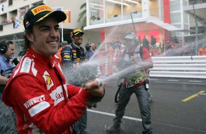 Ferrari's Spanish driver Fernando Alonso and Red Bull Racing's Australian driver Mark Webber spray champagne at the Circuit de Monaco.