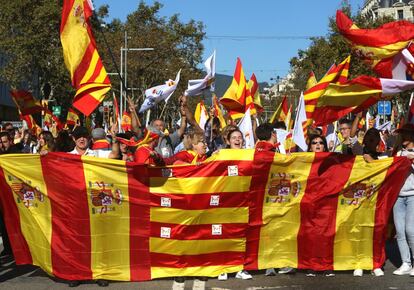Manifestantes sujetan banderas de España y Cataluña a modo de pancarta en la marcha en Barcelona.