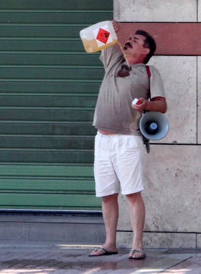 Un hombre se rocía con gasolina frente a una sede de una entidad bancaria griega.