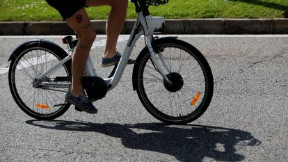 Una hombre transita la madrileña calle Alcalá con una bicicleta del servicio público Bicimad el Día Mundial de la Bicicleta