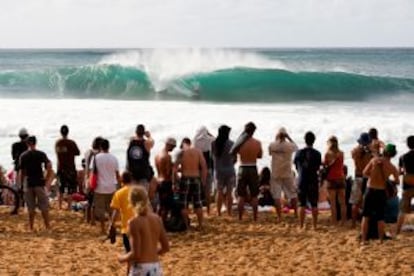 Surfistas y aficionados durante un torneo de surf en el Banzai Pipeline, uno de los mejores tubos de la isla de Oahu, en Hawai.