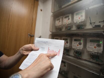 Un usuario comprueba la factura de la luz en el cuarto de contadores de su edificio.