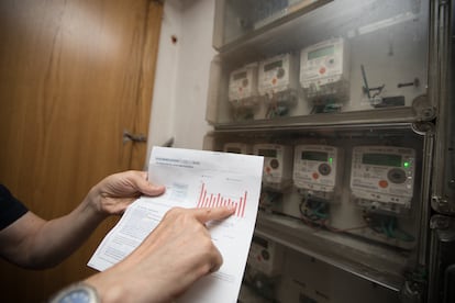 Un usuario muestra su factura junto al contador de luz en su domicilio en Madrid, en una foto de archivo.