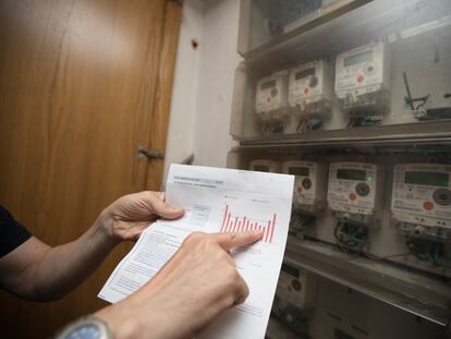Un usuario muestra su factura junto al contador de luz en su domicilio en Madrid, en una foto de archivo.