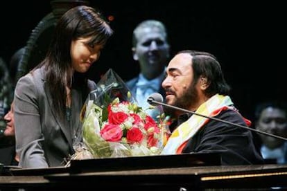 Luciano Pavarotti recibe un ramo de flores tras finalizar su concierto en Hong Kong.