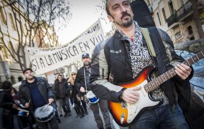 Gustavo, en la marcha de m&uacute;sicos, puntea su guitarrra. 