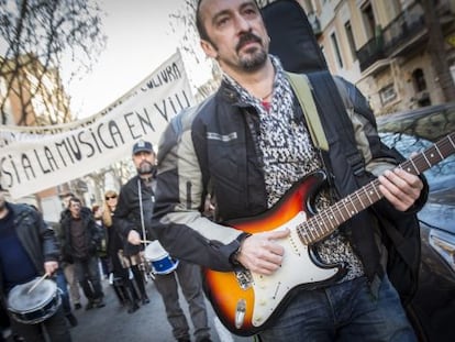 Gustavo, en la marcha de m&uacute;sicos, puntea su guitarrra. 