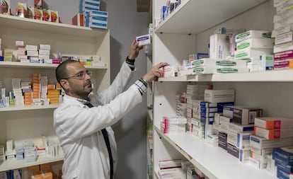 Un farmacéutico dispensa medicamentos en una farmacia de Sevilla.
