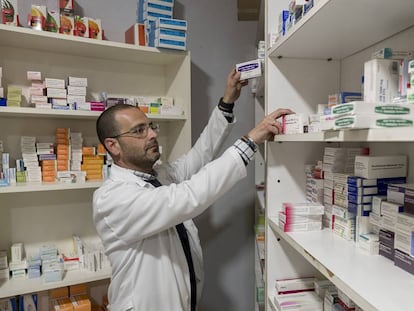 Un farmacéutico dispensa medicamentos en una farmacia de Sevilla. 