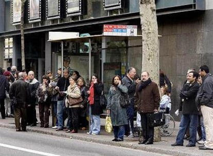 Viajeros esperan en una parada de la calle de Aribau por la huelga de autobuses de Barcelona.