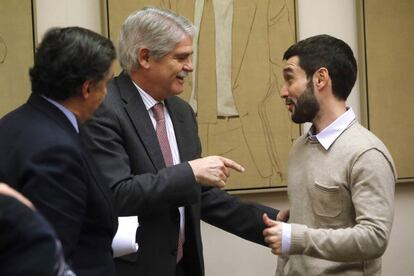 MADRID, 21/12/2016.- El ministro de Asuntos Exteriores, Alfonso Dastis (i) conversa con el diputado de Podemos, Pablo Bustinduy, momentos antes de la Comisión de Exteriores en el Congreso de los Diputados en Madrid.