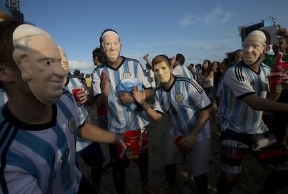 Aficionados argentinos con la careta del Papa Francisco y de Leo Messi