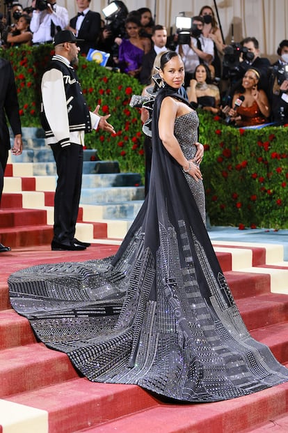 La cantante Alicia Keys, con un vestido palabra de honor combinado con una capa que lleva bordado el skyline de Nueva York. El look es obra de Ralph Lauren.