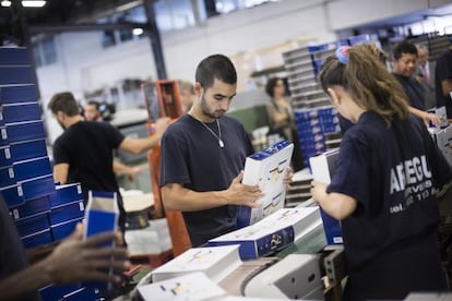 Trabajadores de la empresa encuadernadora colocando en un estuche los primeros ejemplares de la 23&ordf; edici&oacute;n del Diccionario de la lengua espa&ntilde;ola de la RAE.