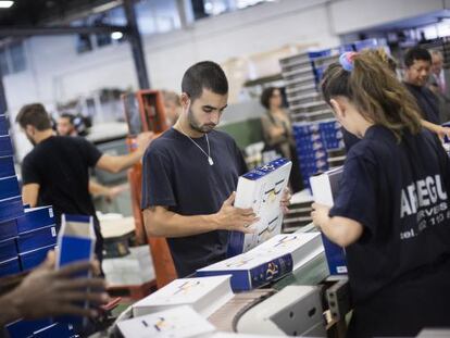 Trabajadores de la empresa encuadernadora colocando en un estuche los primeros ejemplares de la 23&ordf; edici&oacute;n del Diccionario de la lengua espa&ntilde;ola de la RAE.