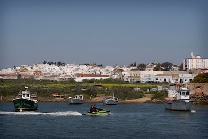 Una moto de agua y unos barcos de pesca navegan en la desembocadura del Guadiana, en Ayamonte, una de las zonas de Huelva en las que crece el tráfico de hachís por la presión en el Estrecho de Gibraltar