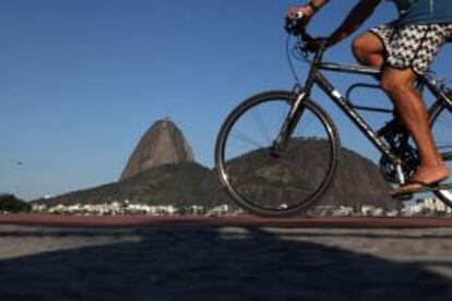 Turistas aprovechan la tarde de sol y calor en la playa de Botafogo con el cerro turístico de Pan de Azúcar al fondo, en la ciudad de Río de Janeiro (Brasil). EFE/Archivo