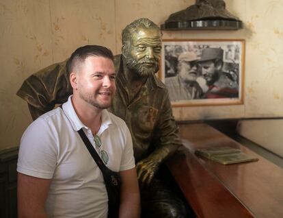 El turista ruso Igor posa para una foto junto a la estatua del escritor estadounidense Ernest Hemingway, en el bar Floridita en La Habana, Cuba.