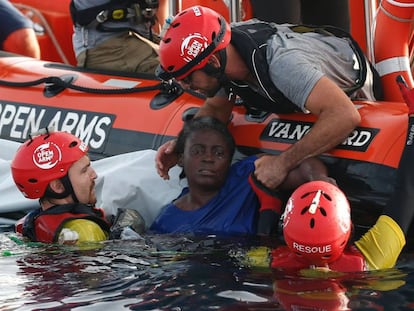 Tres miembros de Open Arms rescatan a una mujer a 85 millas de la costa libia, el pasado julio. 