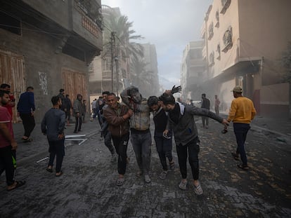 Palestinos ayudaban el lunes a un hombre herido tras los bombardeos israelíes por las calles de Rafah, Gaza.