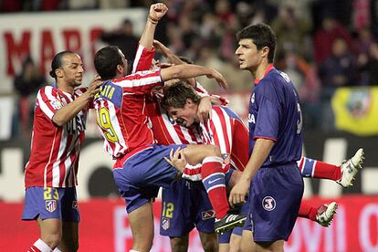 Luccin, Salva y Fernando Torres abrazan a Antonio López tras su gol, que dio la victoria al Atlético en el Manzanares, en presencia del deportivista César.