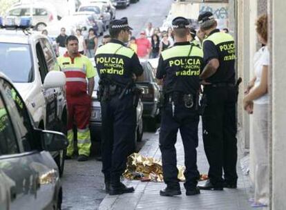 Tres policías rodean el cadáver de la niña atropellada fallecida.