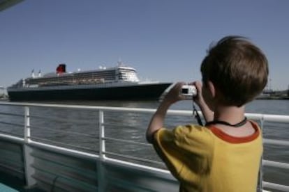 Un niño toma una foto de un gran barco crucero.