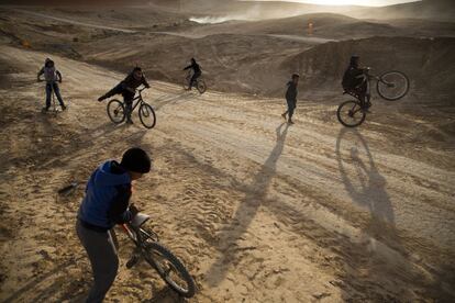 Varios niños beduinos conducen sus bicicletas cerca del vertedero de Dudaim, en Beerseba (Israel).