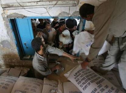 Trabajadores de la Agencia de Naciones Unidas para los Refugiados Palestinos distribuyen comida en un campo de la ciudad de Gaza.