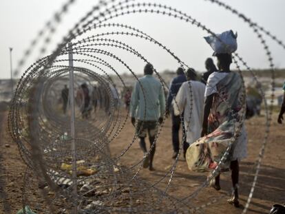 Decenas de desplazados caminan junto a la base de la ONU en Juba, Sud&aacute;n del Sur, el 16 de enero.