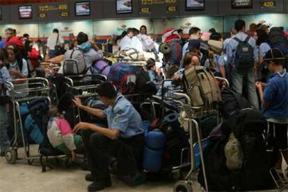 Un grupo de pasajeros espera su turno el pasado verano para facturar en Barajas, Madrid.