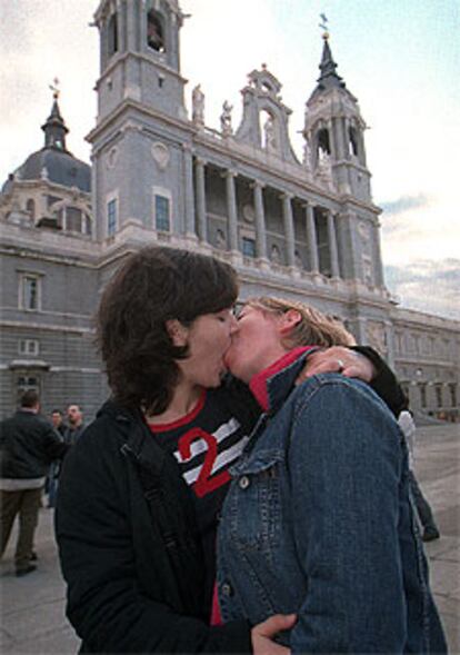 Dos mujeres se besan apasionadamente ante la catedral de la Almudena.