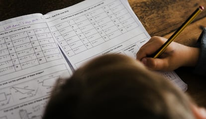 Niño estudiando y escribiendo a mano