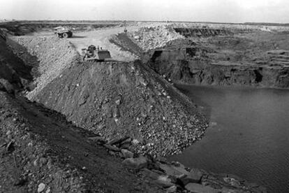 Tareas para rellenar de piedras la balsa de Aznalcóllar en el lugar de la rotura que causó el vertido de 1998.