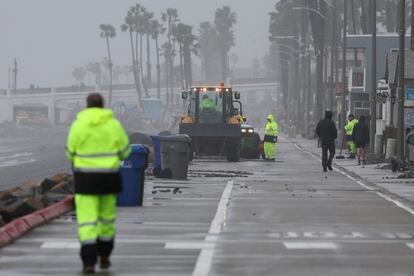 Workers begin to clean up debris from a storm, in Oceanside, California, U.S., February 6, 2024.