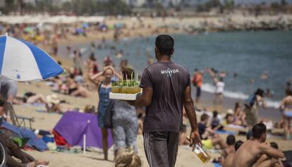 Un vendedor ambulante con una bandeja de mojitos en la Barceloneta.