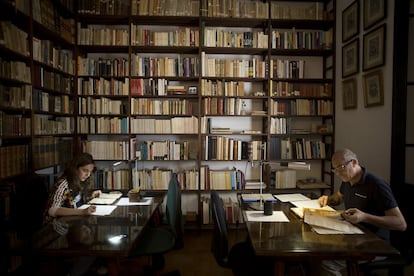 En la imagen, dos personas estudian antiguos legajos y libros en del archivo del palacio de la Casa Medina Sidonia, en 2019.
