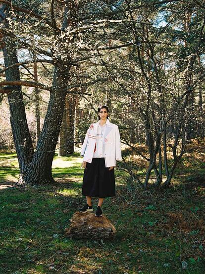 Con camisa y chaqueta de patchwork upcyclingde Moisés Nieto, pantalón negro ancho de Psophía y zapatillas de piel vegana de Veja.