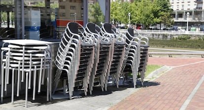 Sillas y mesas apiladas de un restaurante sin actividad en Bilbao.