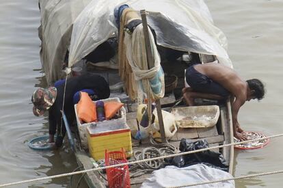 Unos pescadores limpian sus capturas en el río Tonle Sap, en Phnom Penh (Camboya).