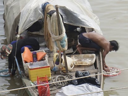 Unos pescadores limpian sus capturas en el río Tonle Sap, en Phnom Penh (Camboya).