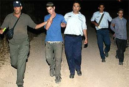 Un colono es arrestado por un policía israelí esta madrugada en un puesto ilegal a las afueras de la ciudad de Nablús.