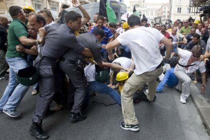 Varios manifestantes forcejean con la policía durante la protesta de ayer en L&#39;Aquila.