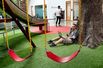 Joshua Carpentier, un empleado de la 'start up' Essential trabaja en un parque infantil dentro de las oficinas de Playground Global, en Palo Alto. Playground financia y apoya a 'starts up'  que desarrollan nueva tecnología centrada en la inteligencia artificial. Carpetier afirma que le resulta útil tirarse del tobogán una vez al día como recordatorio de la necesidad de divertirse y nunca tomarse demasiado en serio lo que uno hace. Palo Alto, California, agosto, 2018.